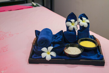 Spa treatment setup with towels and flowers
