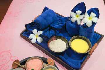 Spa treatment setup with towels and flowers
