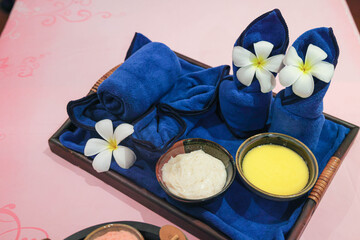 Spa treatment setup with towels and flowers
