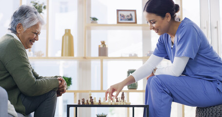 Nurse, old woman and play chess in home, smile and solution with cognitive function in lounge....