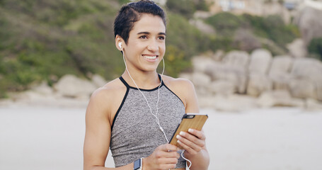 Earphones, phone and woman on beach for fitness, workout or running for cardio training. Happy,...