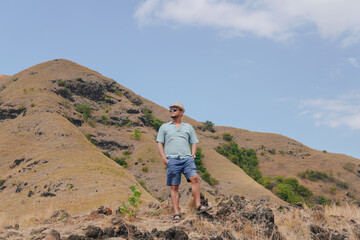 Fototapeta premium Happy young Asian man enjoying holiday in Golo Mori mountain hill, Labuan Bajo.
