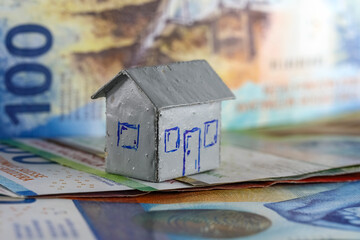 Theme of finance and housing, paper money in Swiss francs and a model of a house