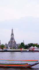 Boat trip on the Chao Phraya River with Wat Arun in the background in Bangkok, Thailand.