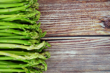Bunch of fresh green asparagus stems on wooden background