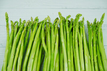 Bunch of fresh green asparagus stems on wooden background