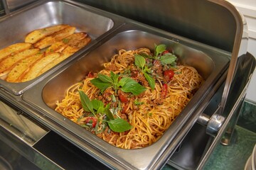 Close up of spaghetti with garlic bread in buffet
