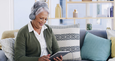 Old woman, relax and headphones with tablet on sofa for streaming movie, online film and podcast. Retirement, senior person and happy with digital app in home for listening to audio playlist or video