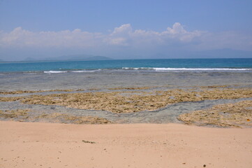 Obraz premium Sea background, beach and sand, sunny day, rock from waters, clear sky