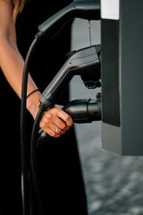 Electric vehicle charging station with a close-up of a person connecting the charger