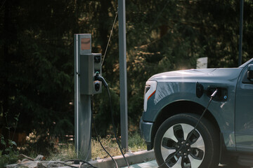 Electric vehicle charging station in a green forested area during the day