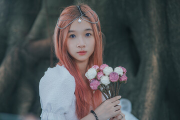 Young woman with flowers in a forest setting.