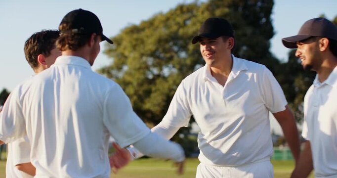 Raising arm, Diverse male cricketers in whites shaking hands and patting backs on field