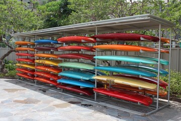 Colorful surfboards stored under a canopy