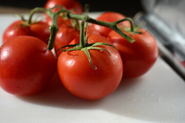 Close-up of fresh vine tomatoes on a kitchen counter. Ideal for food magazines, vegetable ads, kitchenware promotions, and healthy eating concepts.