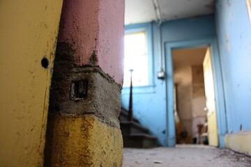 Interior view of a dilapidated hallway with colorful walls