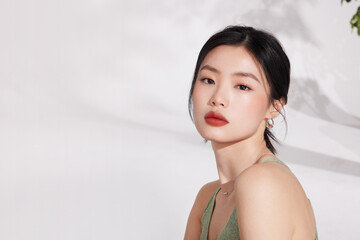 Young woman with elegant makeup and a subtle expression.