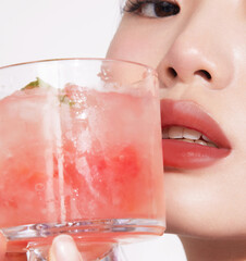 Close-up of a young woman enjoying a refreshing drink.