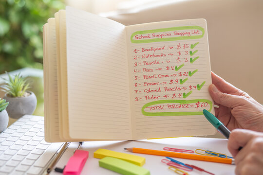 Parent checking a shopping list while calculating expenses for school supplies, totaling 60 dollars for a backpack, notebooks, and stationery items