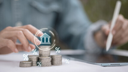 Stack of coins with digital bank icon and interest percentage concept