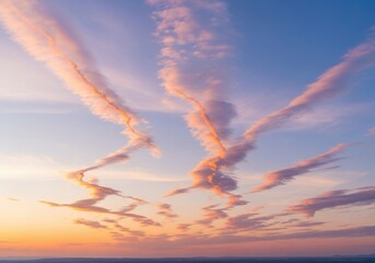 Streaks of pastel clouds in a serene sunrise sky, aerial perspective
