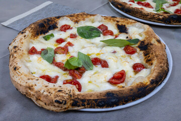 Eating of fresh baked Naples pizza dish in italian pizzeria restaurant, close up