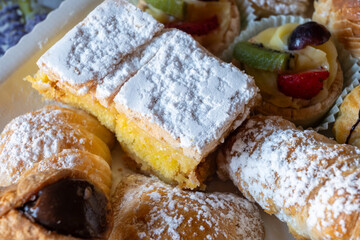 Italian sweet dessert dolce pastry and cakes with cream and fruits on plate made in artisanal...