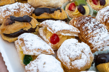 Italian sweet dessert dolce pastry and cakes with cream and fruits on plate made in artisanal...