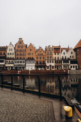 A classic panoramic view of colorful, historic buildings lining a river, with their facades...