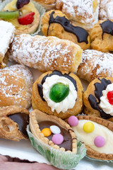 Italian sweet dessert dolce pastry and cakes with cream and fruits on plate made in artisanal bakery in Rome, Italy, close up