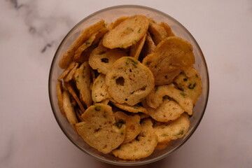 basreng is thinly sliced, fried meatballs. A savory snack. Indonesian food. Served in a glass jar.