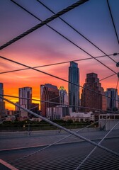 Obraz premium Austin Texas Skyline at Dusk Seen Through Bridge Cables, A Vibrant Vista