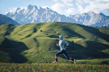Trail runner running on the high altitude grassland mountain top