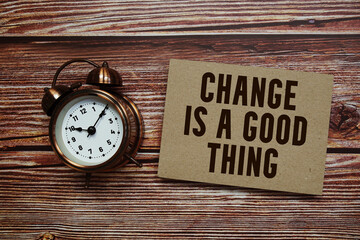 Chang Is A Good Thing! text with alarm clock on wooden background