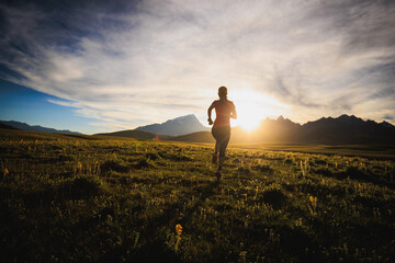 Trail runner running on the high altitude grassland mountain top
