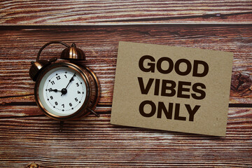 Good Vibes Only text with alarm clock on wooden background