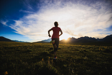 Trail runner running on the high altitude grassland mountain top
