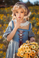 Young woman in vintage dress holding flowers in a sunflower field.