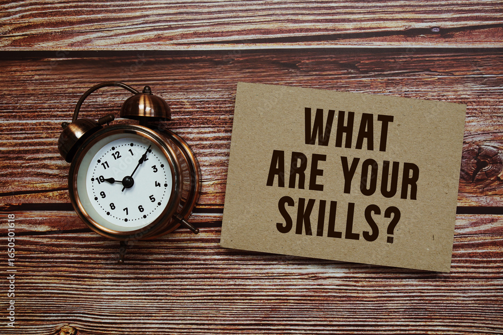 Poster what are your skills? text with alarm clock on wooden background