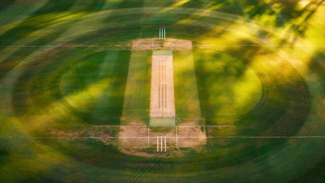 Cricket pitch with wickets on green grass sports field aerial view