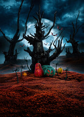 Mysterious tree, pumpkins, bats and zombie hands rising out of the ground in spooky night