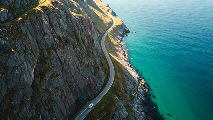 Obraz premium Dramatic Coastal Road on a Rocky Cliffside with Turquoise Ocean Waters Perfect for Travel Adventures and Scenic Drives along the Norwegian Coastline