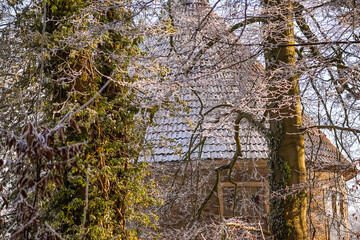 Stone castle tower shining though winter frost tree branches on a sunny and cold winter morning...
