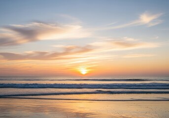 Obraz premium Beautiful ocean sunset with golden light reflecting on the water and gentle waves rolling onto the sandy shore