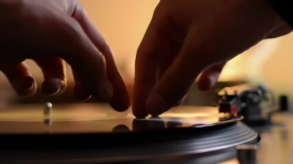 Close-up of hands adjusting a turntable
