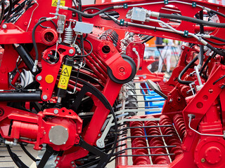 Close-up view of an agricultural or industrial machine showing a detailed hydraulic system with multiple valves, connectors, and black hoses.
