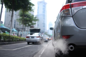 City street, exhaust fumes from car