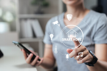 Close-up of a person using a smartphone to tap a smart home interface, icons for security, camera, light, thermostat and music show IoT connectivity, remote control and energy-efficient living