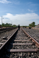 a boy walking on railway