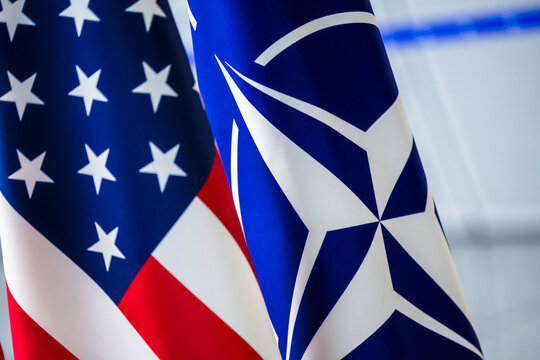 Close-up of the United States flag alongside the NATO flag, symbolizing alliance and cooperation.